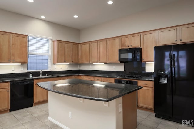 kitchen with sink, a center island, light tile patterned floors, dark stone counters, and black appliances