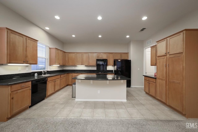 kitchen with light tile patterned flooring, black appliances, dark stone counters, and a kitchen island