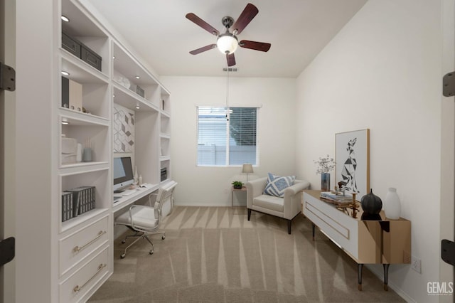 carpeted office with ceiling fan and built in desk