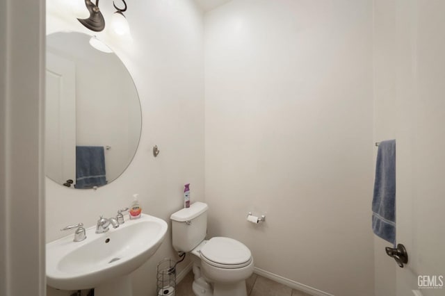 bathroom with toilet, tile patterned flooring, and sink