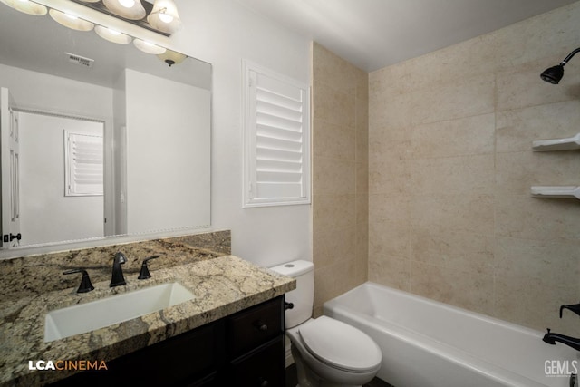 full bathroom with tiled shower / bath, vanity, and toilet