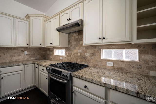 kitchen with light stone countertops, stainless steel range with gas stovetop, backsplash, and cream cabinetry