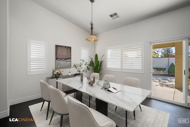 dining area with dark hardwood / wood-style floors and vaulted ceiling