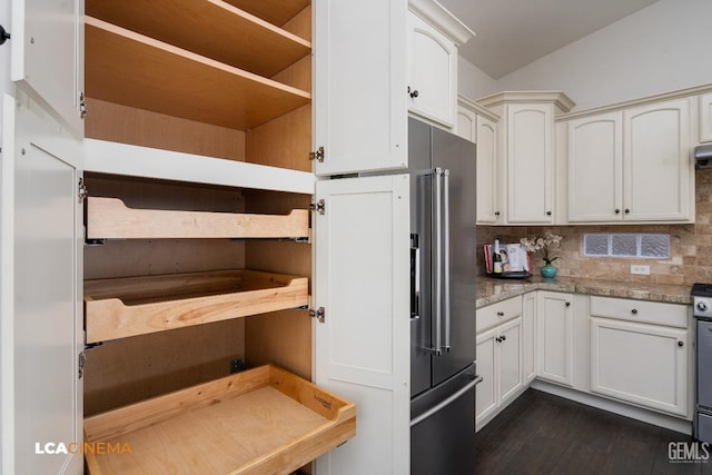 kitchen with stainless steel stove, dark wood-type flooring, light stone counters, tasteful backsplash, and white cabinets