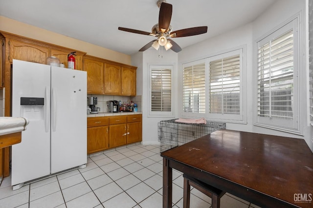 11011 Southwales Ct, Bakersfield, CA 93312 - kitchen with white refrigerator with ice dispenser, brown cabinetry, a wealth of natural light, and a ceiling fan