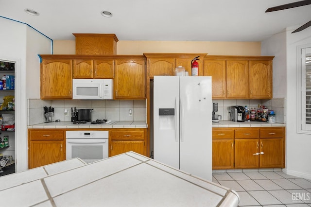 11011 Southwales Ct, Bakersfield, CA 93312 - kitchen featuring light tile patterned flooring, white appliances, ceiling fan, and backsplash