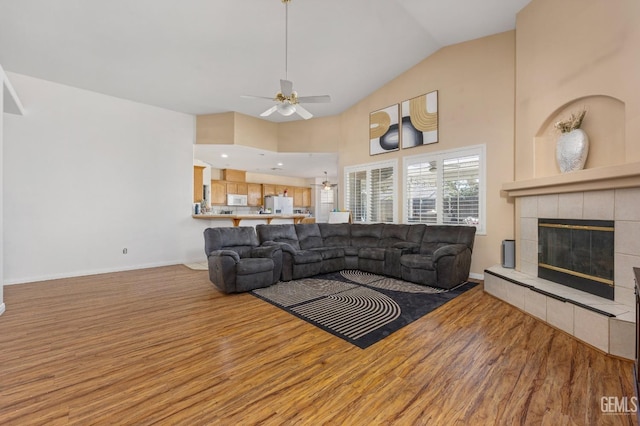 11011 Southwales Ct, Bakersfield, CA 93312 - living area with high vaulted ceiling, a ceiling fan, a fireplace, wood finished floors, and baseboards