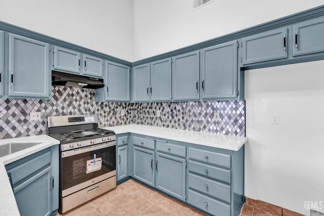 5403 Cascade Ridge St, Bakersfield, CA 93307 - kitchen featuring stainless steel gas range, blue cabinetry, under cabinet range hood, and light tile patterned flooring
