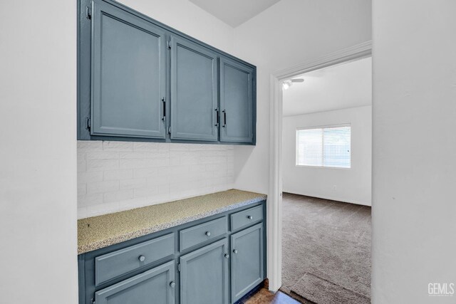 5403 Cascade Ridge St, Bakersfield, CA 93307 - kitchen with backsplash, light countertops, blue cabinetry, and dark carpet
