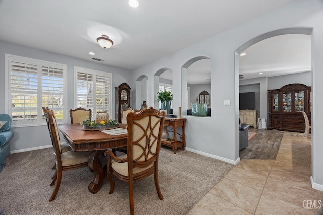 8628 Sandpines Dr, Bakersfield, CA 93312 - dining space featuring baseboards, light carpet, recessed lighting, arched walkways, and light tile patterned floors