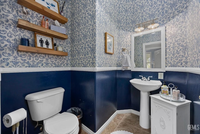 8628 Sandpines Dr, Bakersfield, CA 93312 - half bath with wallpapered walls, tile patterned floors, toilet, and a wainscoted wall