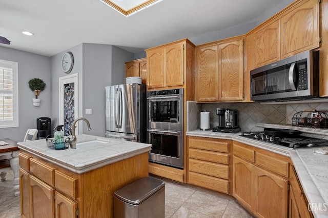 8628 Sandpines Dr, Bakersfield, CA 93312 - kitchen with appliances with stainless steel finishes, tile countertops, a sink, backsplash, and a kitchen island with sink
