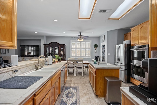 8628 Sandpines Dr, Bakersfield, CA 93312 - kitchen with stainless steel appliances, a sink, a ceiling fan, recessed lighting, and light tile patterned flooring