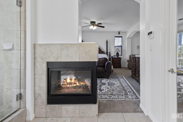8628 Sandpines Dr, Bakersfield, CA 93312 - tiled living room featuring a ceiling fan, a tile fireplace, and arched walkways