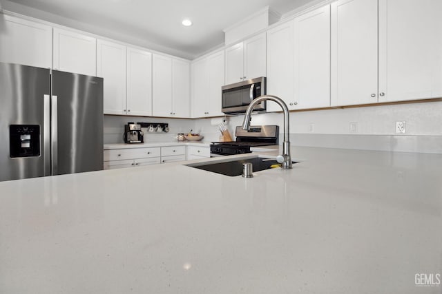 3116 Seymour St, Tulare, CA 93274 - kitchen with appliances with stainless steel finishes, a sink, white cabinets, recessed lighting, and light stone counters