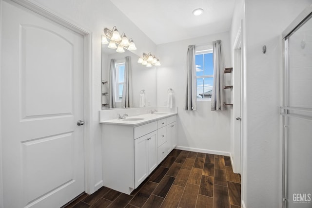 3116 Seymour St, Tulare, CA 93274 - full bath with wood finished floors, baseboards, double vanity, a shower with door, and recessed lighting