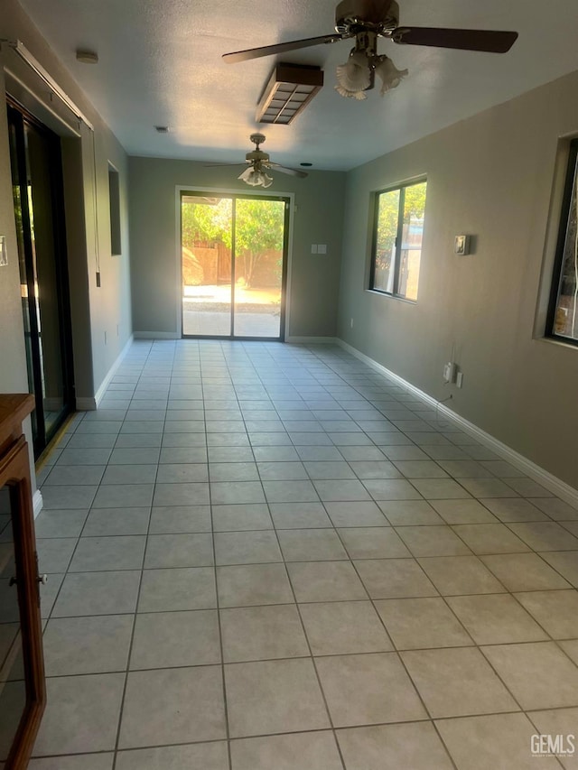 1325 Bayne Ct, Bakersfield, CA 93307 - empty room featuring ceiling fan, plenty of natural light, light tile patterned floors, and a textured ceiling