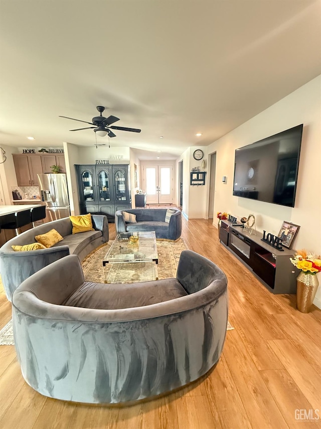 living room with light hardwood / wood-style flooring and ceiling fan