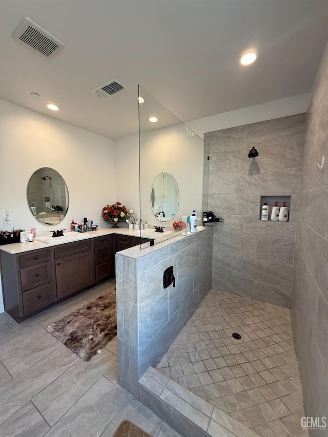 bathroom with vanity and tiled shower