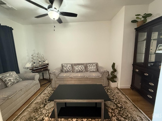 living room featuring ceiling fan and dark hardwood / wood-style flooring