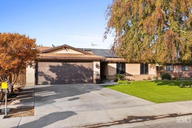 view of front of home with a front yard, solar panels, and a garage