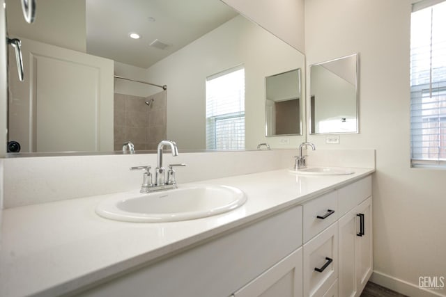 full bathroom with double vanity and a shower