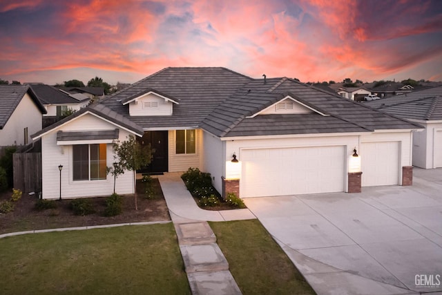 traditional-style house with an attached garage, driveway, and brick siding