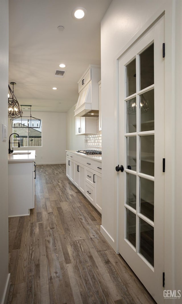 hallway featuring a chandelier, dark wood-style floors, a sink, and recessed lighting