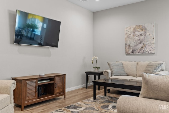 living area featuring baseboards and wood finished floors