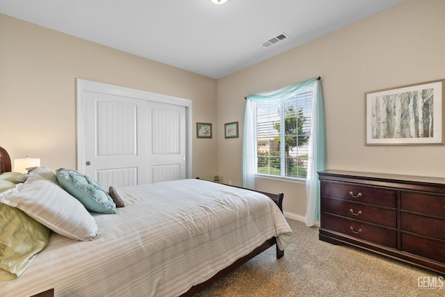 bedroom featuring a closet, visible vents, baseboards, and light carpet