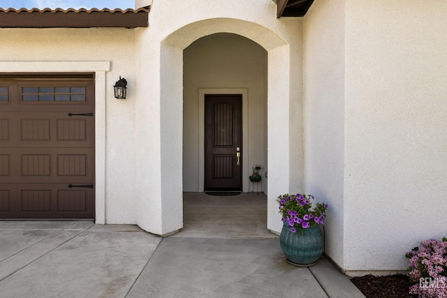 entrance to property featuring stucco siding and a tile roof