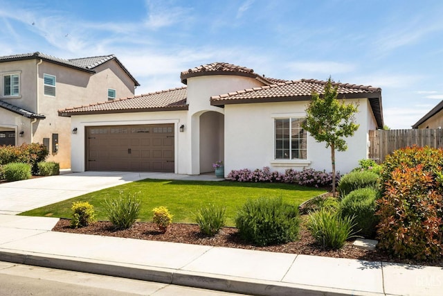 mediterranean / spanish-style home with stucco siding, an attached garage, a front lawn, and fence