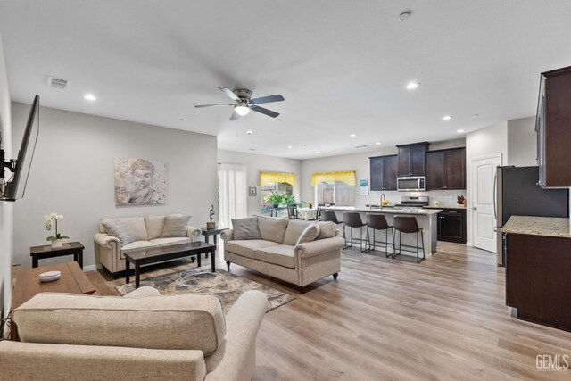 living area with recessed lighting, light wood-type flooring, visible vents, and a ceiling fan