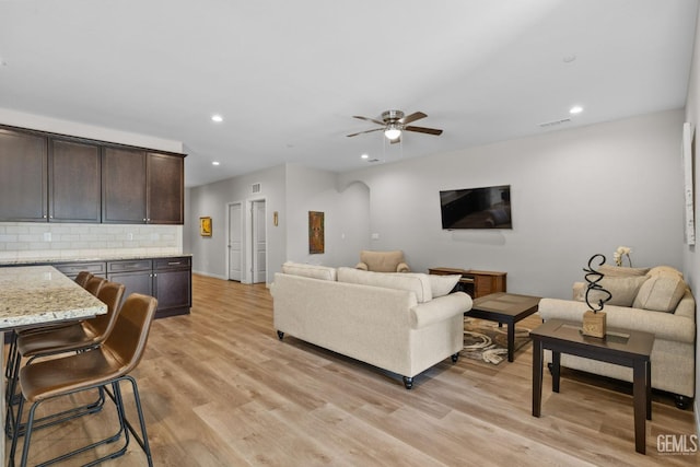 living area featuring light wood-type flooring, a ceiling fan, and recessed lighting
