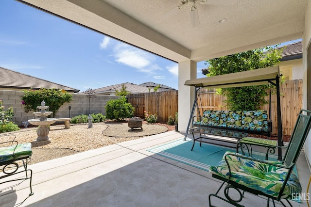 view of patio / terrace with a fire pit, a ceiling fan, and a fenced backyard