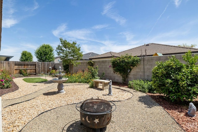 view of yard with a fenced backyard, a patio area, and an outdoor fire pit
