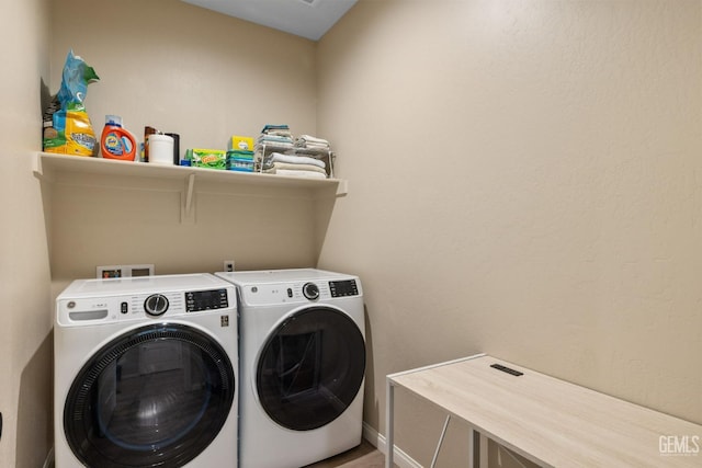 washroom featuring baseboards, washer and clothes dryer, and laundry area