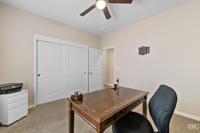 office space featuring light colored carpet, ceiling fan, and baseboards