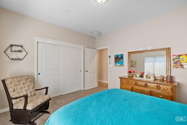bedroom with baseboards, carpet floors, and a closet