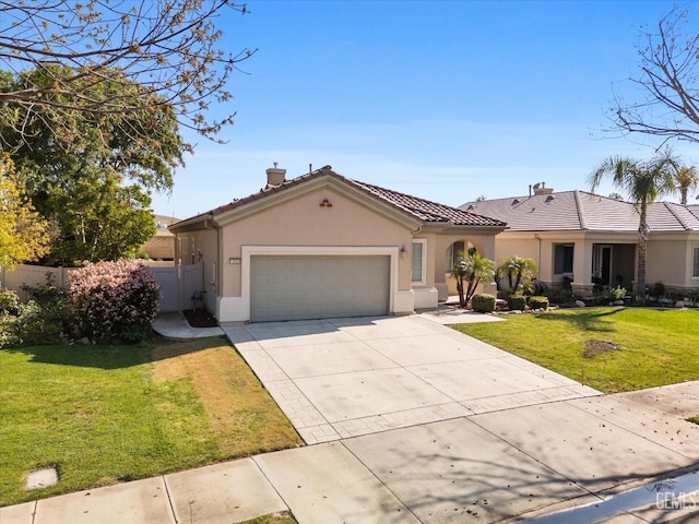 mediterranean / spanish home with a front yard, a garage, concrete driveway, fence, and stucco siding