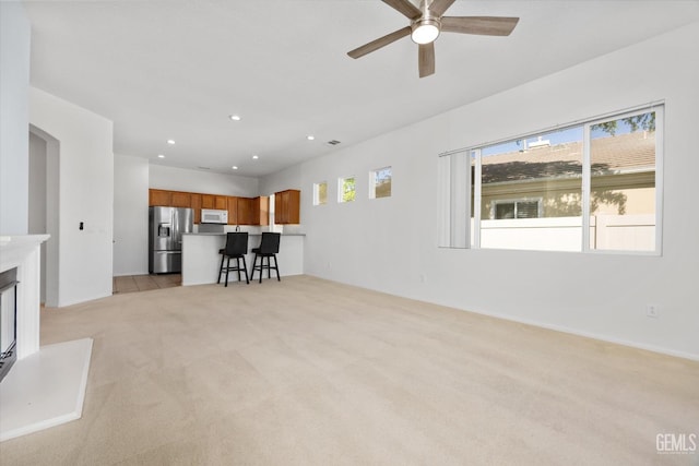 unfurnished living room with ceiling fan, recessed lighting, and light colored carpet