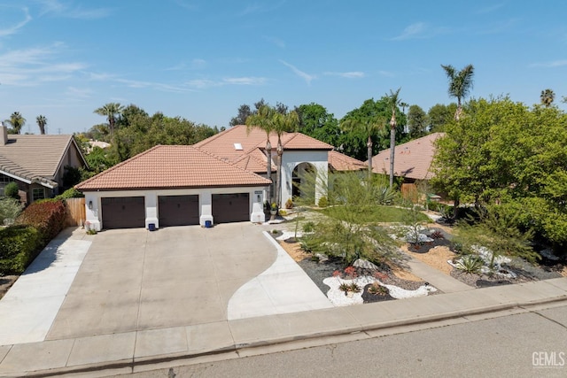 3121 Emerald Arbor St, Bakersfield, CA 93314 - mediterranean / spanish-style house featuring a tiled roof, an attached garage, driveway, and stucco siding