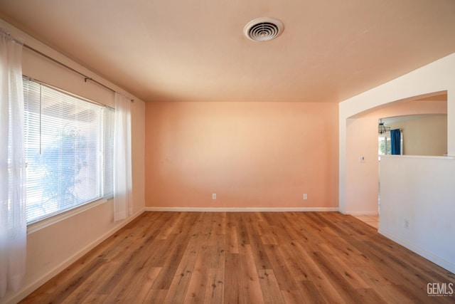 spare room featuring a healthy amount of sunlight and hardwood / wood-style flooring