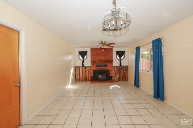 unfurnished living room featuring a fireplace, light tile patterned floors, and ceiling fan