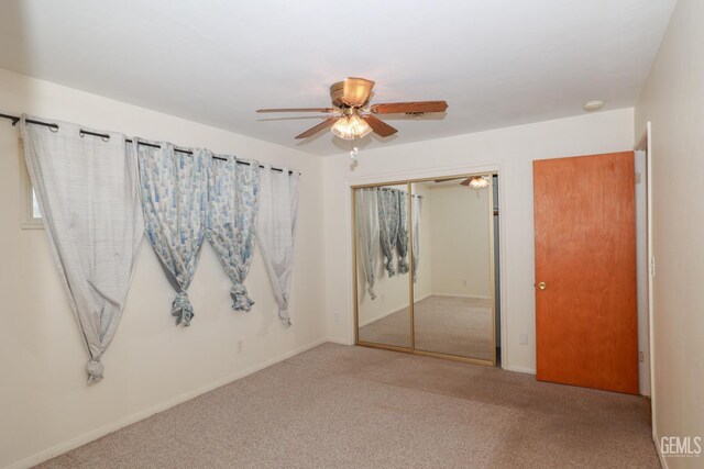 unfurnished bedroom with carpet floors, a closet, and ceiling fan