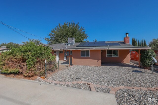 view of front of home with a carport and solar panels