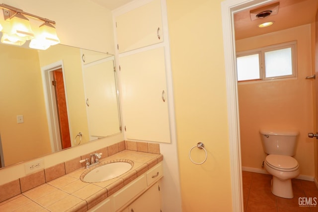 bathroom with tile patterned flooring, vanity, and toilet