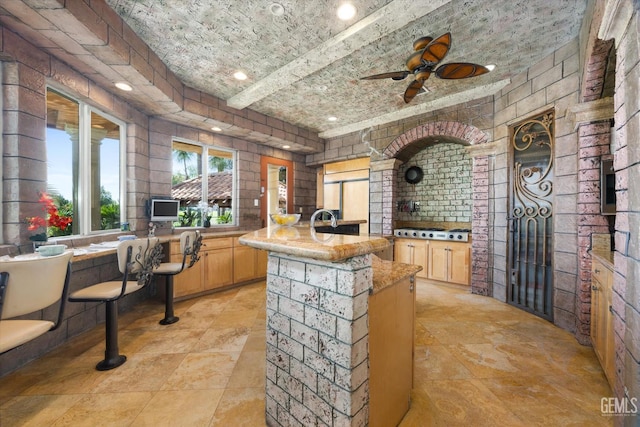 4905 Islands Dr, Bakersfield, CA 93312 - kitchen with light brown cabinets, light countertops, paneled built in fridge, a ceiling fan, and a kitchen island