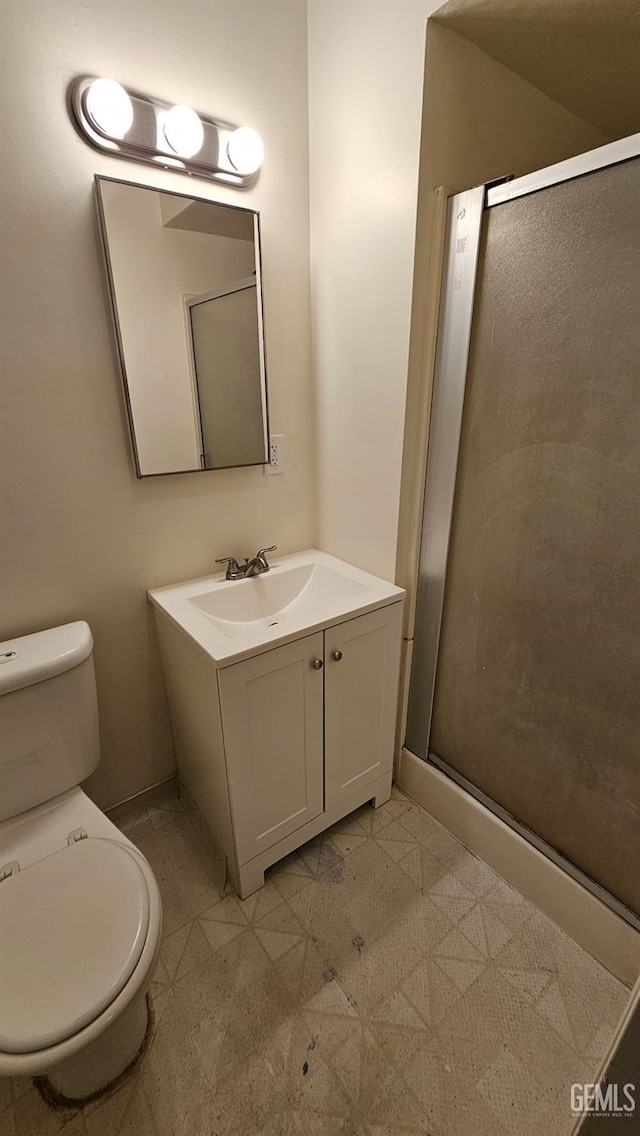 full bathroom with a stall shower, vanity, and toilet