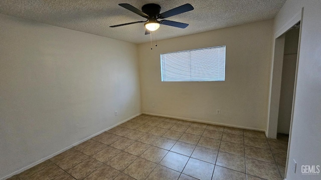 unfurnished bedroom with light tile patterned floors, a textured ceiling, a ceiling fan, and baseboards